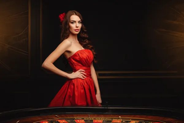A young woman relaxing with her phone while dynamic casino elements float around her, illustrating the smooth mobile experience offered by the MALI WIN app.
