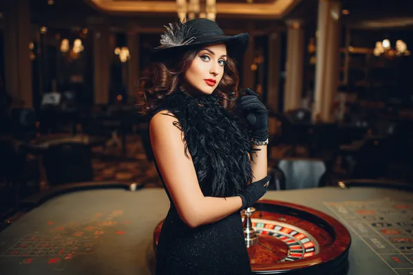 A professional dealer in a tuxedo greeting players at the roulette table, symbolizing the authentic live casino feel at MALI WIN.