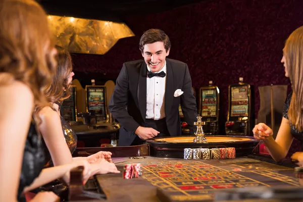 A stylish woman beside vibrant slot machines displaying glowing sevens, showcasing the variety of top slots at MALI WIN.